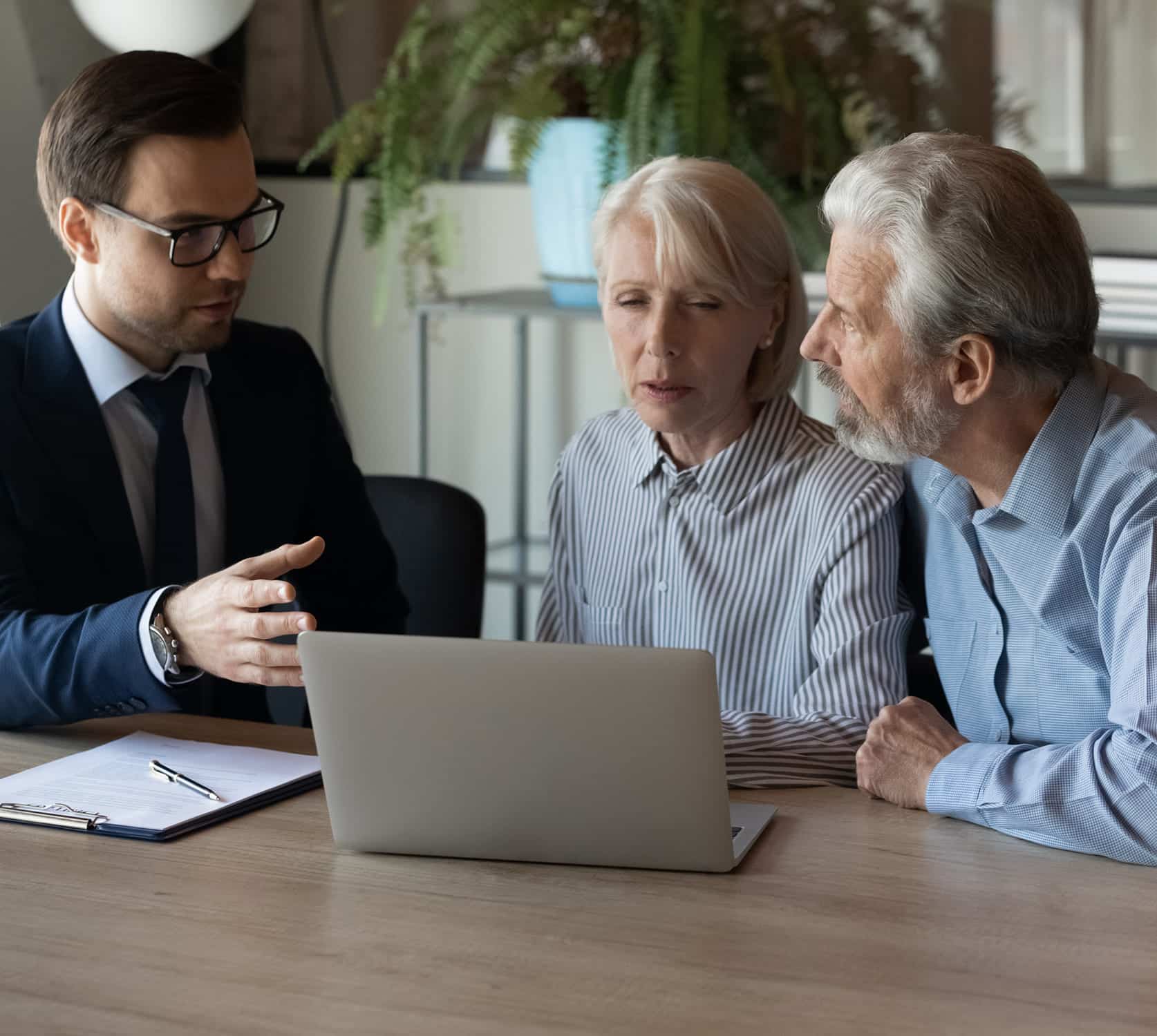 Business meeting with a young professional and older couple discussing finance
