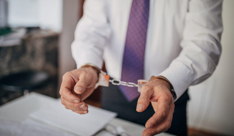 Hands in handcuffs showing a legal situation.