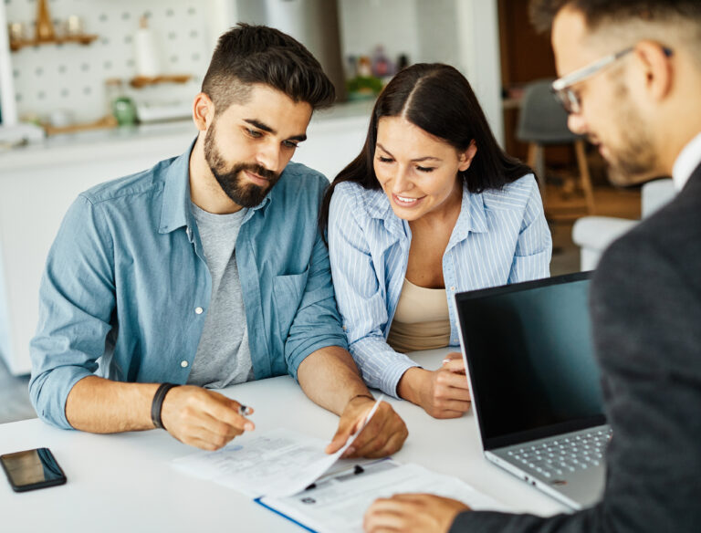 Couple discussing documents with a professional in an office